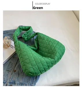 Detailed view of the green quilted tote bag with diamond stitching on a white surface