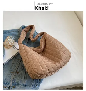 Detail of khaki quilted puffer tote bag on denim jacket, casual aesthetic scene