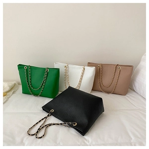 Detail of four colorful tote bags with crocodile pattern and chain woven straps