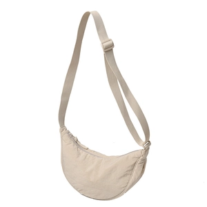 Minimalist beige nylon half-moon crossbody bag with adjustable strap and zipper closure