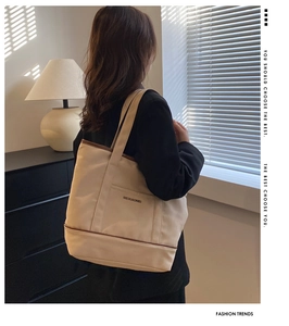 Détail du sac cabas en toile beige avec garniture marron dans un intérieur chic