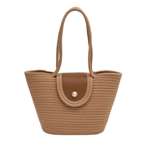 Handwoven khaki straw bucket bag with brown leather flap and pearl button closure