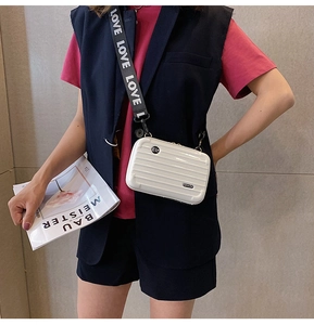 Mini white hardshell suitcase crossbody bag with grooved texture and LOVE printed strap