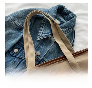 Détail de la poignée en toile durable avec bordure en cuir marron et coutures renforcées
