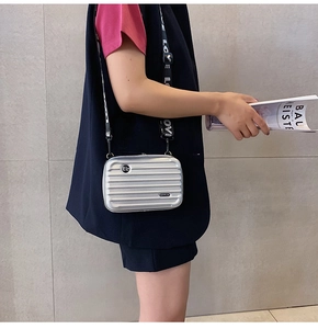Silver mini suitcase crossbody bag with logo strap and hard shell grooved texture