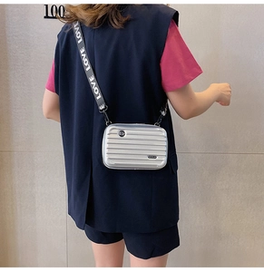 Detail of silver mini suitcase crossbody bag with printed wide LOVE strap and grooves