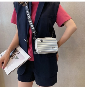Detailed view of mini suitcase crossbody bag with silver shell and LOVE logo strap
