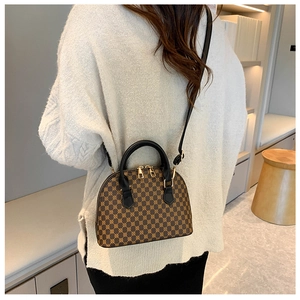 Detailed back view of a brown vintage shell bag worn with a white knit sweater