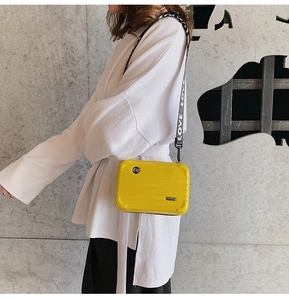 Detail of yellow mini suitcase crossbody bag with a wide LOVE printed nylon shoulder strap