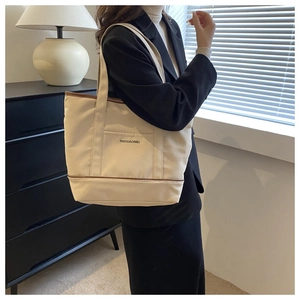 Détail d'un sac cabas en toile minimaliste avec bordures et anses en cuir marron