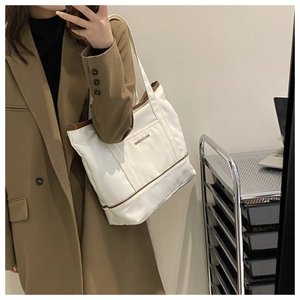 Selfie miroir montrant le sac fourre-tout en toile blanc cassé avec bordure marron
