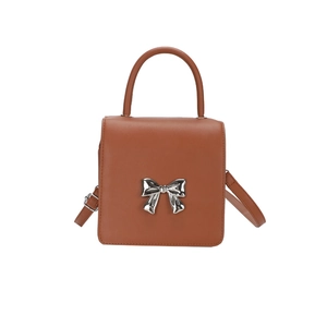 Mini square caramel leather handbag with a silver metal bow and adjustable shoulder strap