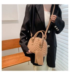 Sac à main matelassé beige avec bandoulière porté avec un blazer noir chic pour femme