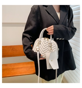 Détail du sac coquillage blanc matelassé avec dorures et pochette enveloppe assortie