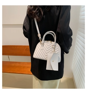 Détail du sac coquille matelassé blanc avec bandoulière réglable et petite pochette