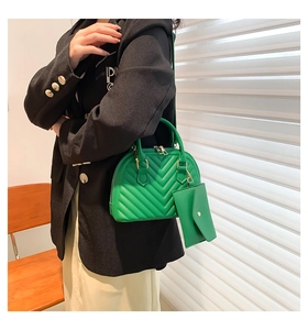 Détail du sac à main vert à surpiqûres en V avec petite pochette et fermeture éclair en métal