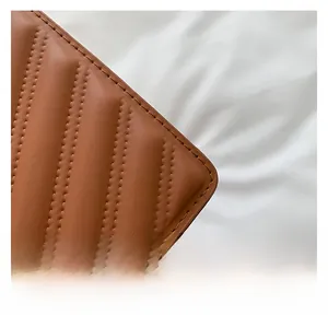 Detail of brown quilted leather texture with elegant diagonal double stitching finish