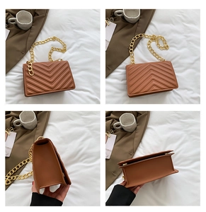 Detail view of caramel quilted crossbody bag with gold chain strap and stitching