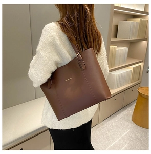 Detail of dark brown faux leather tote bag with elegant gold Fashion & Bag lettering