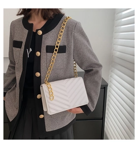 White quilted crossbody bag featuring a chunky gold chain strap and V-shaped stitching