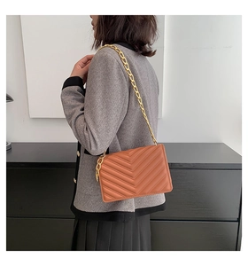 Caramel brown quilted crossbody bag with stylish gold chain strap and V-pattern texture
