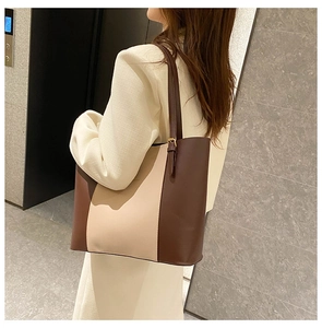 Detail view of large tote bag with color-block leather and adjustable metal buckle