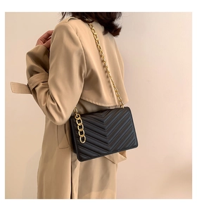 Detail of black chevron quilted leather crossbody bag with premium gold chain strap