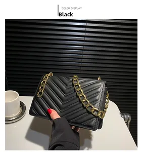 Close-up of black quilted chain shoulder bag with elegant V-stitch pattern and gold chain