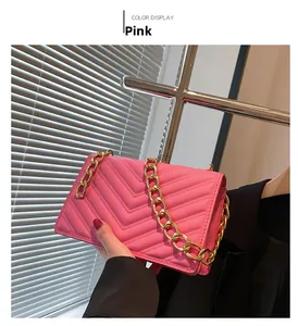 Detail of pink crossbody bag with V-quilted faux leather and bold gold chain strap