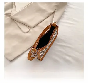 Macro view of brown suede saddle bag showing rhinestones and interior capacity