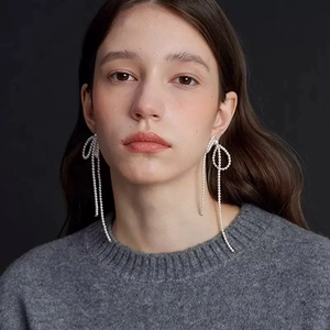 Elegant pearl bow tassel earrings with handmade beadwork on a model for a vintage look