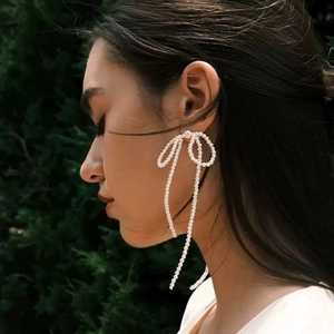 Elegant handmade pearl bow tassel drop earrings shown on model for a graceful style