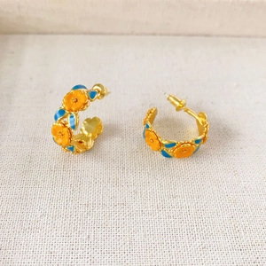 Golden C-shaped enamel camellia earrings with orange flowers and royal blue leaves