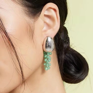 Boucles d'oreilles grappe de raisin perles vertes et sphère argentée sur modèle