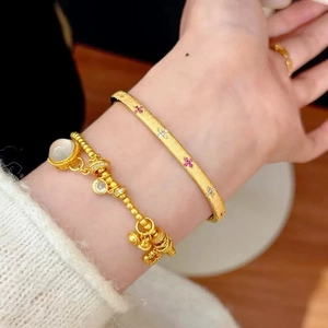 Elegant gold clover jewelry set with engraved bangle and beaded charm bracelet for women