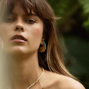 Bohemian tribal turquoise bead earrings and white pearl necklace on female model