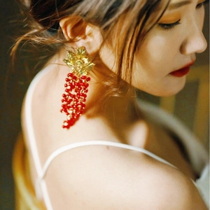 Elegant gold leaf earrings with red pomegranate bead clusters for a vintage grape look