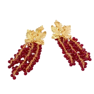 Handmade grape-shaped drop earrings with dark red beads and golden leaves on white background