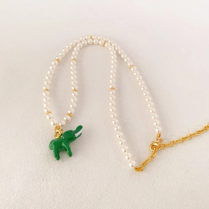 Détail du collier de perles avec pendentif éléphant en émail vert et fermoirs dorés
