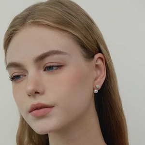 Boucles d'oreilles minimalistes en perles de culture et grain d'argent sur un mannequin