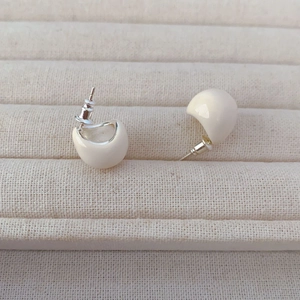 Minimalist cream white enamel puff earrings with 925 silver needles on a beige display