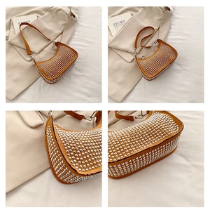Detailed view of yellow suede crescent bag with silver stud accents and fine strap