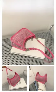 Detailed view of pink crescent bag with silver stud accents and metallic buckles