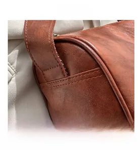 Macro detail of retro brown leather shoulder bag with neat stitching and smooth zipper edges