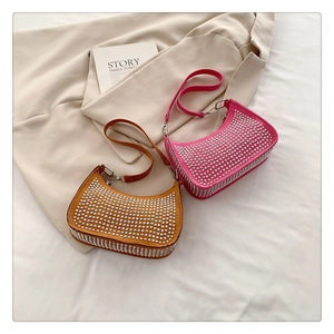 Detail of pink and brown rhinestone crescent bags with metallic studs on fabric
