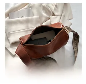 Interior view showing the large capacity of this brown retro cylinder crossbody bag