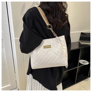 White quilted tote bag featuring gold chain strap and brown accents for daily commuting