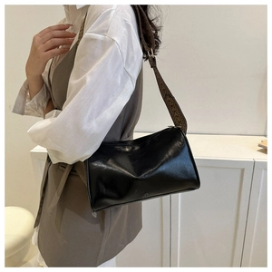 Vista laterale della borsa baguette in pelle PU nera con tracolla geometrica marrone