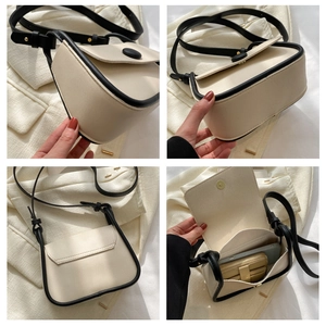 Detail view of cream saddle bag with black piping showing interior and side structure