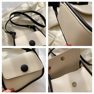 Detail view of contrast color crossbody bag showing stitching and magnetic gold clasp